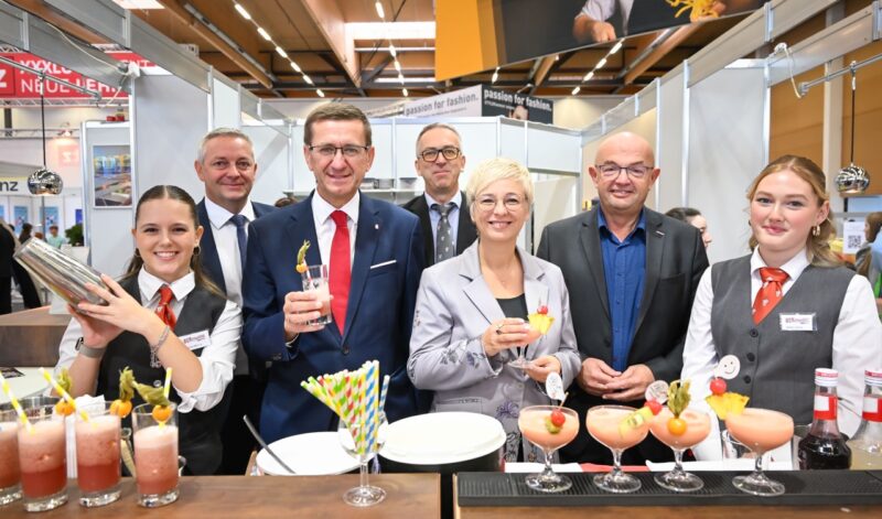 Besuchende genießen Snacks und Getränke am Messestand