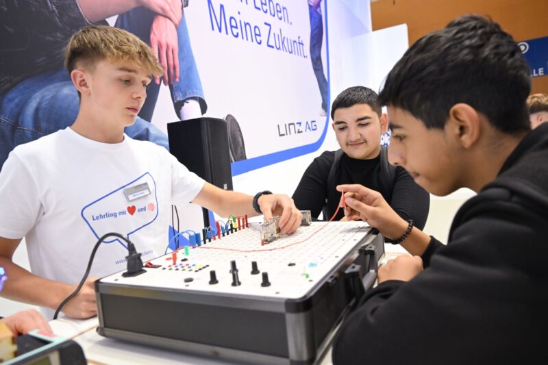 Jugendliche experimentieren an einem technischen Lernstand