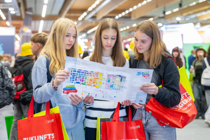 Jugendliche lesen Messeplan