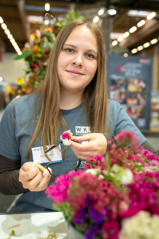 Jugendliche bindet Blumenkranz