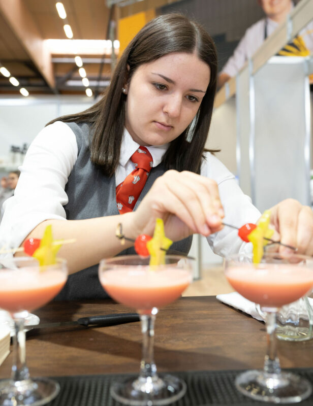 Mädchen dekoriert ein Cocktailglas
