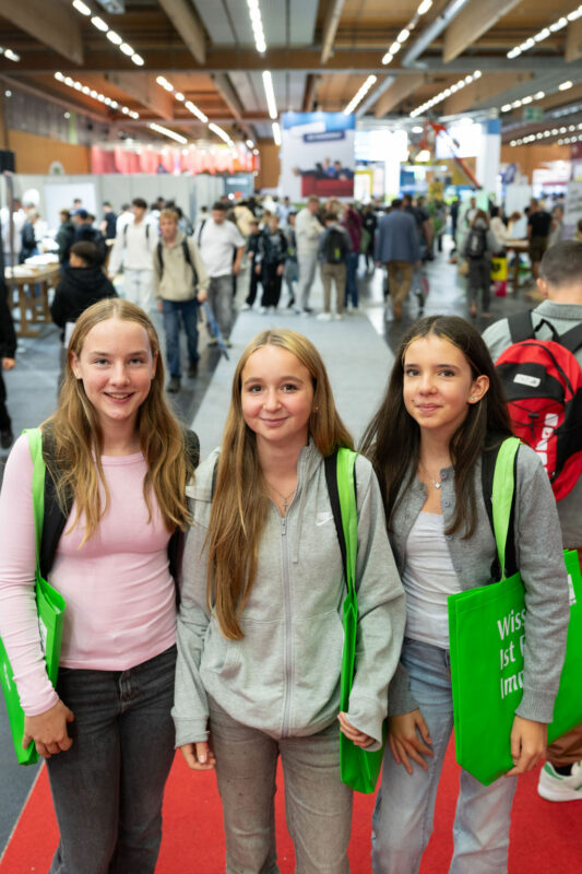 Drei Mädchen bei der Messe 
