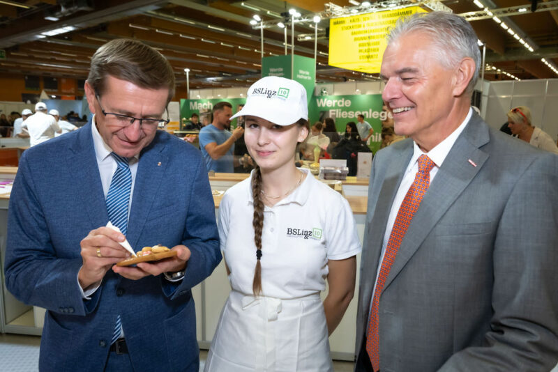 Vertreter der WKO und des Landes OÖ mit Jugendlicher beim Verzieren von Lebkuchen
