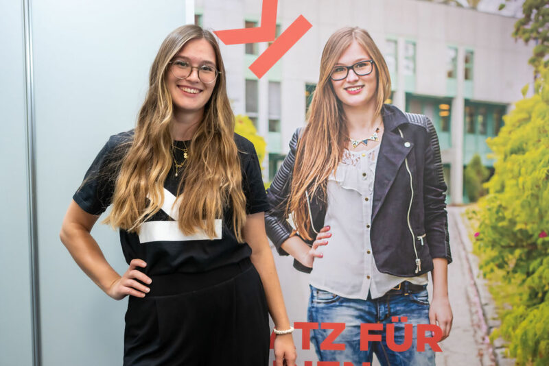 Mädchen posiert vor Plakat